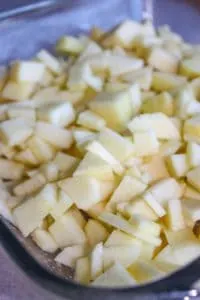 Spreading he prepared apples in the pan.