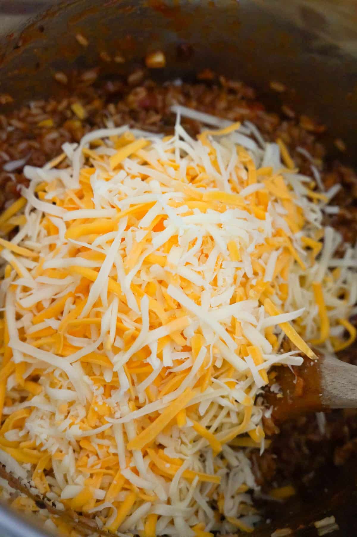shredded mozzarella and cheddar cheese on top of ground beef and rice in an Instant Pot