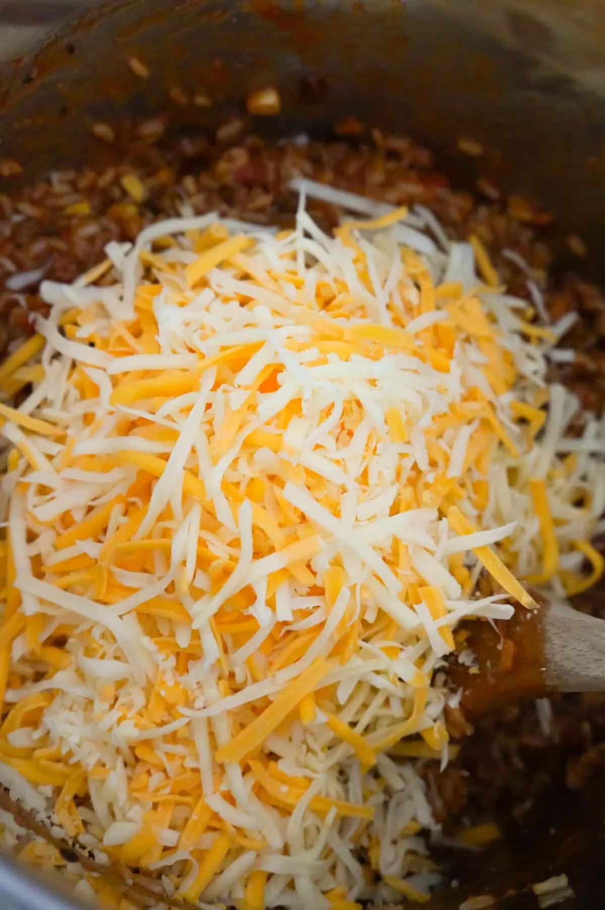 shredded mozzarella and cheddar cheese on top of ground beef and rice in an Instant Pot