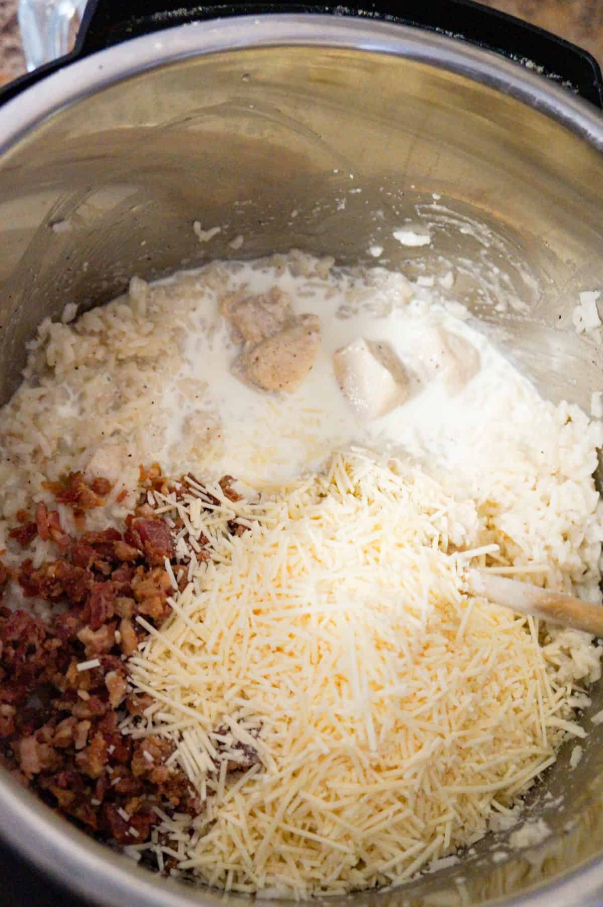 heavy cream, shredded parmesan and crumbled bacon on top of cooked chicken and rice in an Instant Pot