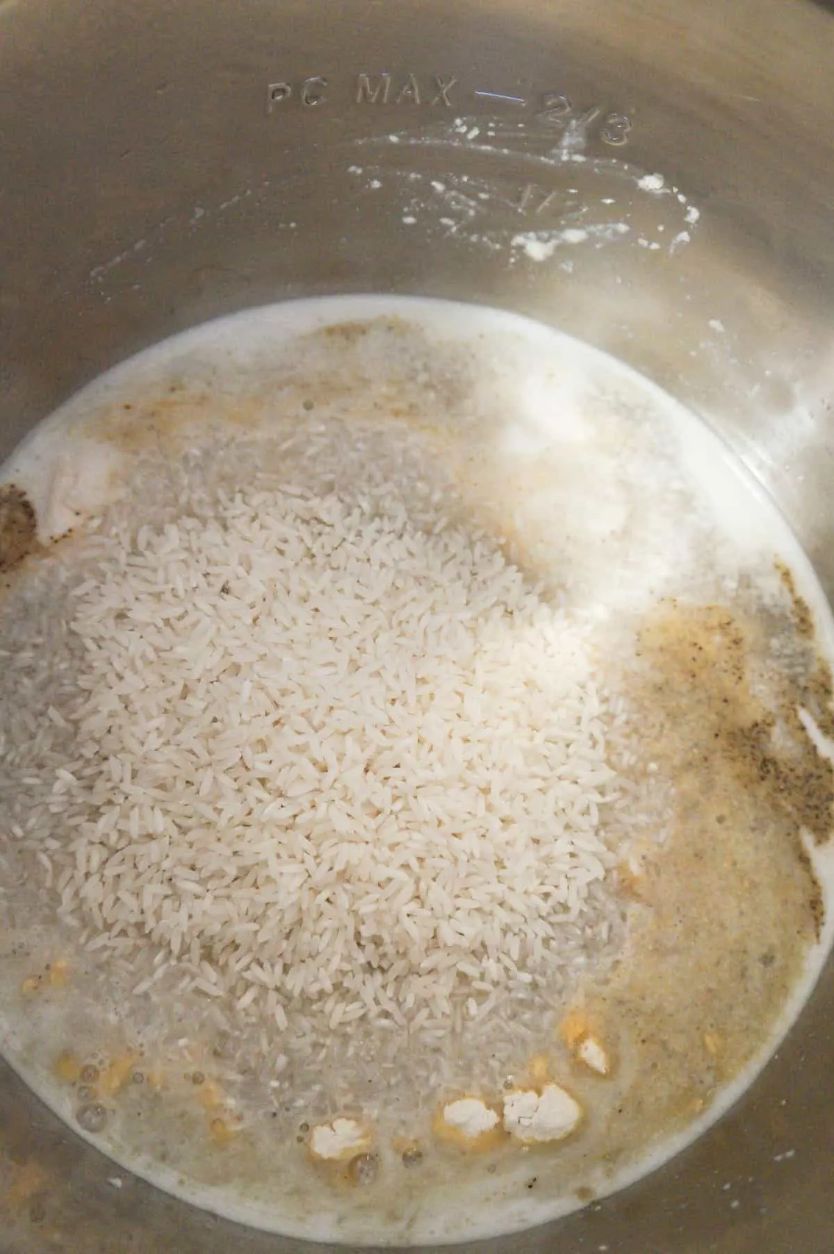 long grain rice on top of chicken, water and spices in an Instant Pot