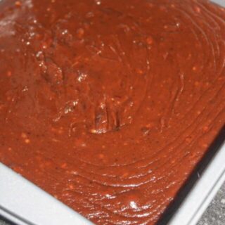 Scraping fudge into the pan.