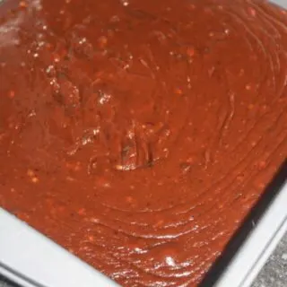 Scraping fudge into the pan.
