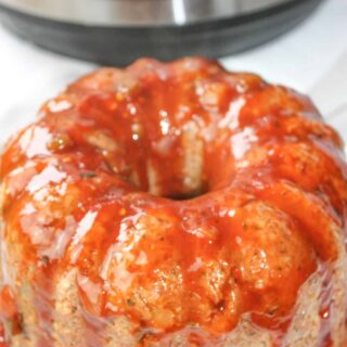 Instant Pot Fancy Meatloaf, draped in sauce, will dress up any dinner table.  This gluten free version has a ribbon of spicy cheese through its center that spices it up a bit!