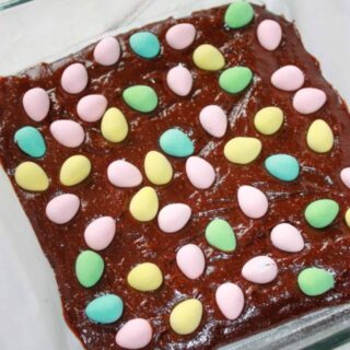Spreading the mini eggs evenly over top of the brownie batter.