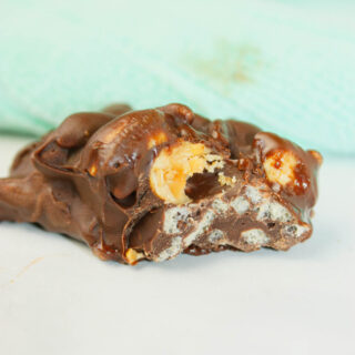 Crispy Peanut Clusters are little mounds of sweet, perfection that crunch with every bite.  The glossy chocolate shell melts on your tongue while the crisp rice and roasted peanuts create a satisfying snap.