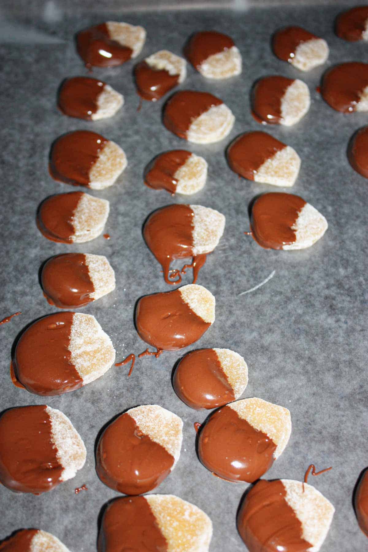 Dip the candied ginger in the melted chocolate and then transfer to the prepared baking pan.