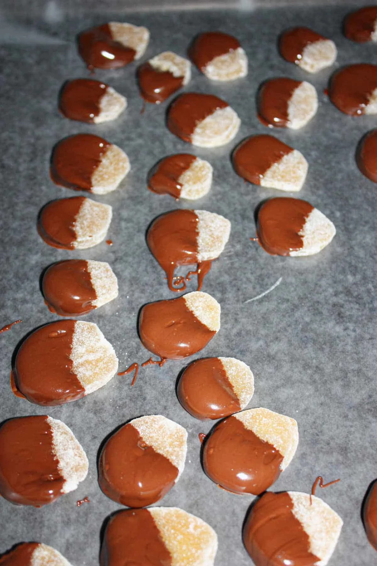 Dip the candied ginger in the melted chocolate and then transfer to the prepared baking pan.